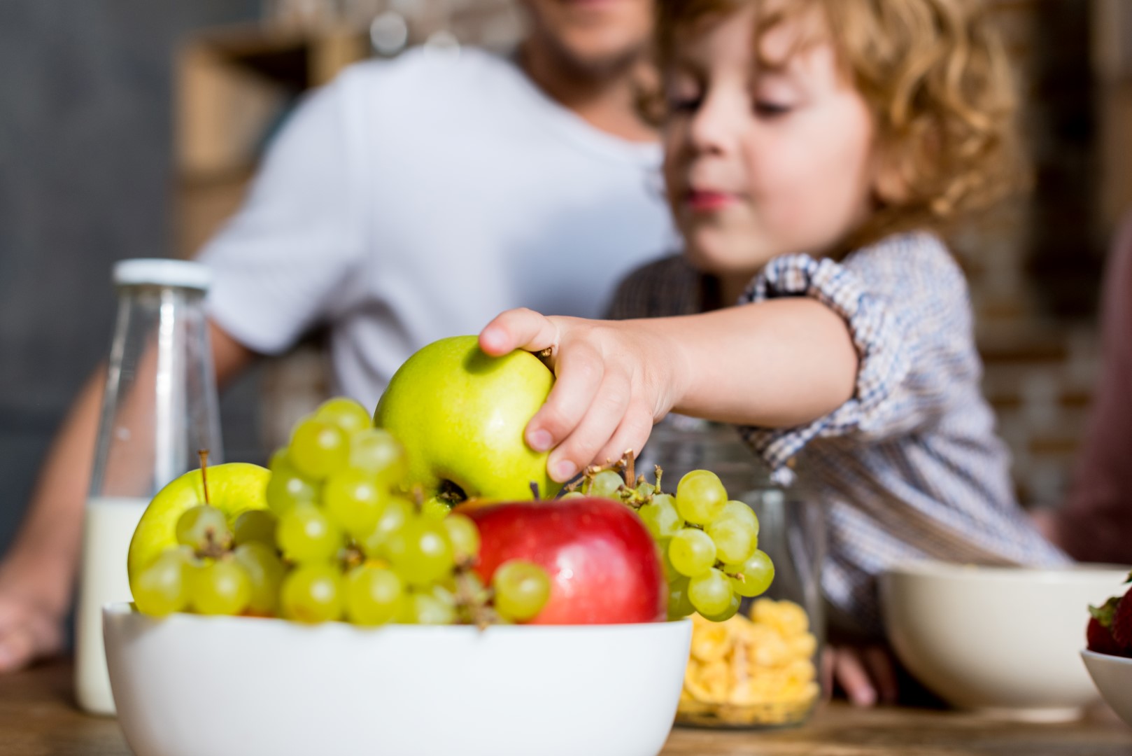 close-up view of cute little boy eating fresh fruits at breakfast